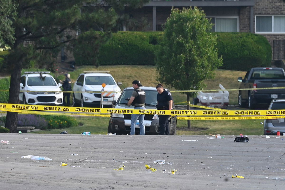 <i>Matt Marton/AP</i><br/>Investigators look over the scene of an overnight mass shooting in Willowbrook