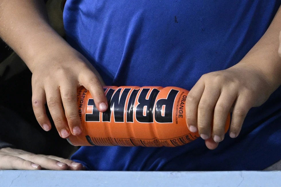 A child holds a PRIME hydration drink prior to a baseball game between the Los Angeles Dodgers and the Arizona Diamondbacks, March 31, 2023, in Los Angeles. An influencer-backed energy drink that has earned viral popularity among children is facing scrutiny from federal lawmakers and health experts over its potentially dangerous levels of caffeine. Senator Chuck Schumer on Sunday, July 9, 2023 called on the Food and Drug Administration to investigate Prime. 