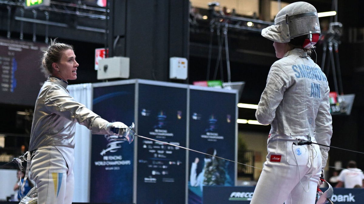 <i>Andreas Solaro/AFP via Getty Images</i><br/>An official of the International Fencing Federation (FIE) speaks Smirnova as she sits on the fencing strip.