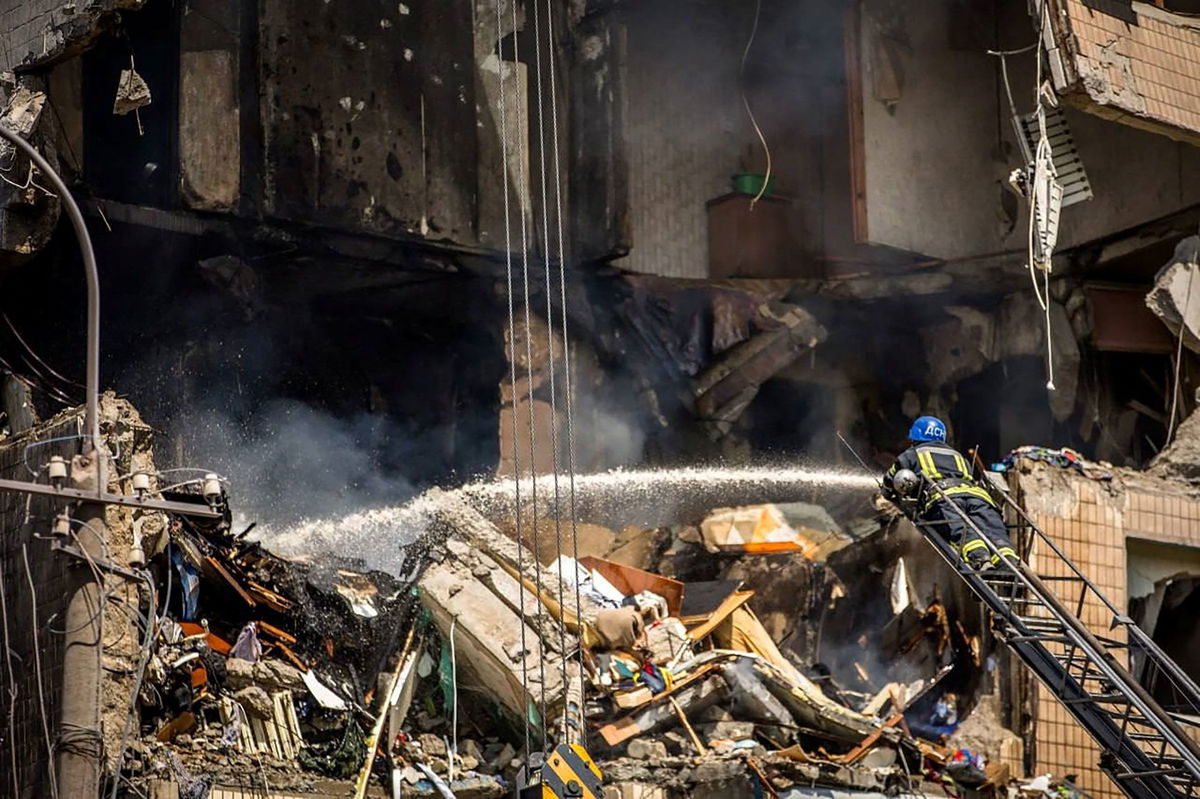 <i>State Emergency Service of Ukraine/Reuters</i><br/>A firefighter is seen working on one of the damaged buildings on Monday.