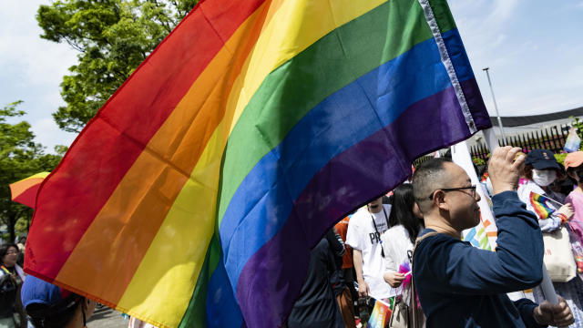 A participate raises a rainbow flag during the pride parade in Tokyo, 23 Apr.  (Photo by Yusuke Harada/NurPhoto via Getty Images)