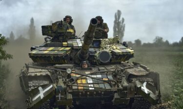 Ukrainian soldiers on a tank ride along the road towards their positions near Bakhmut