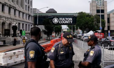 Authorities stand near barricades at the Fulton County courthouse Aug. 7 in Atlanta.