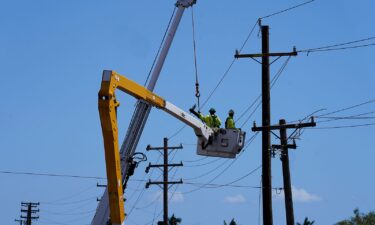 Linemen work on poles in Lahaina