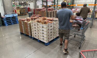 Shoppers peruse a display of Rainer cherries while pushing carts through a Costco warehouse Tuesday