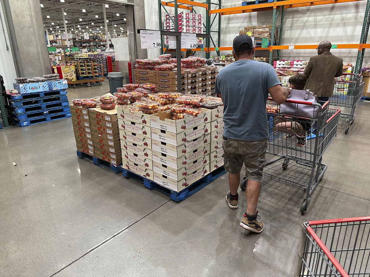 <i>David Zalubowski/AP</i><br/>Shoppers peruse a display of Rainer cherries while pushing carts through a Costco warehouse Tuesday