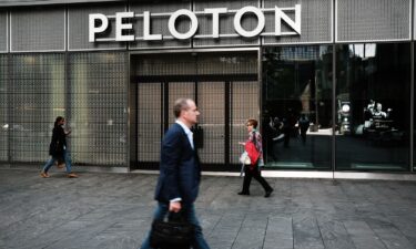 People walk by Peloton Studios on May 12