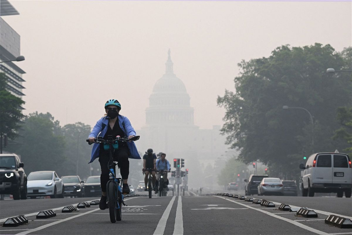 <i>Mandel Ngan/AFP via Getty Images</i><br/>A cyclist rides under a blanket of haze partially obscuring the US Capitol in Washington