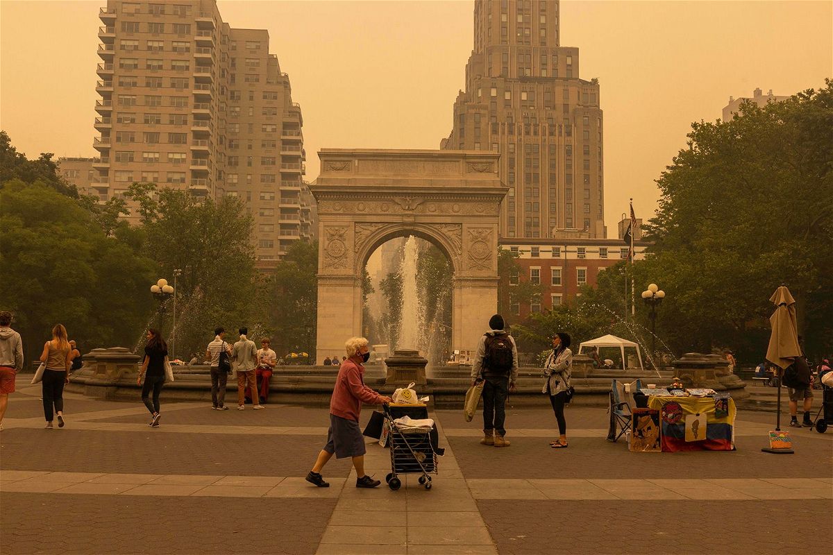 <i>Alex Kent/Bloomberg/Getty Images</i><br/>Pedestrians are pictured here at Washington Square Park as smoke from Canada wildfires blankets New York on June 7.