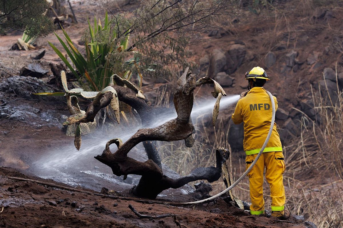 <i>Patrick T. Fallon/AFP/Getty Images</i><br/>A caretaker photographs the site of a home destroyed by the Maui wildfires in Kula