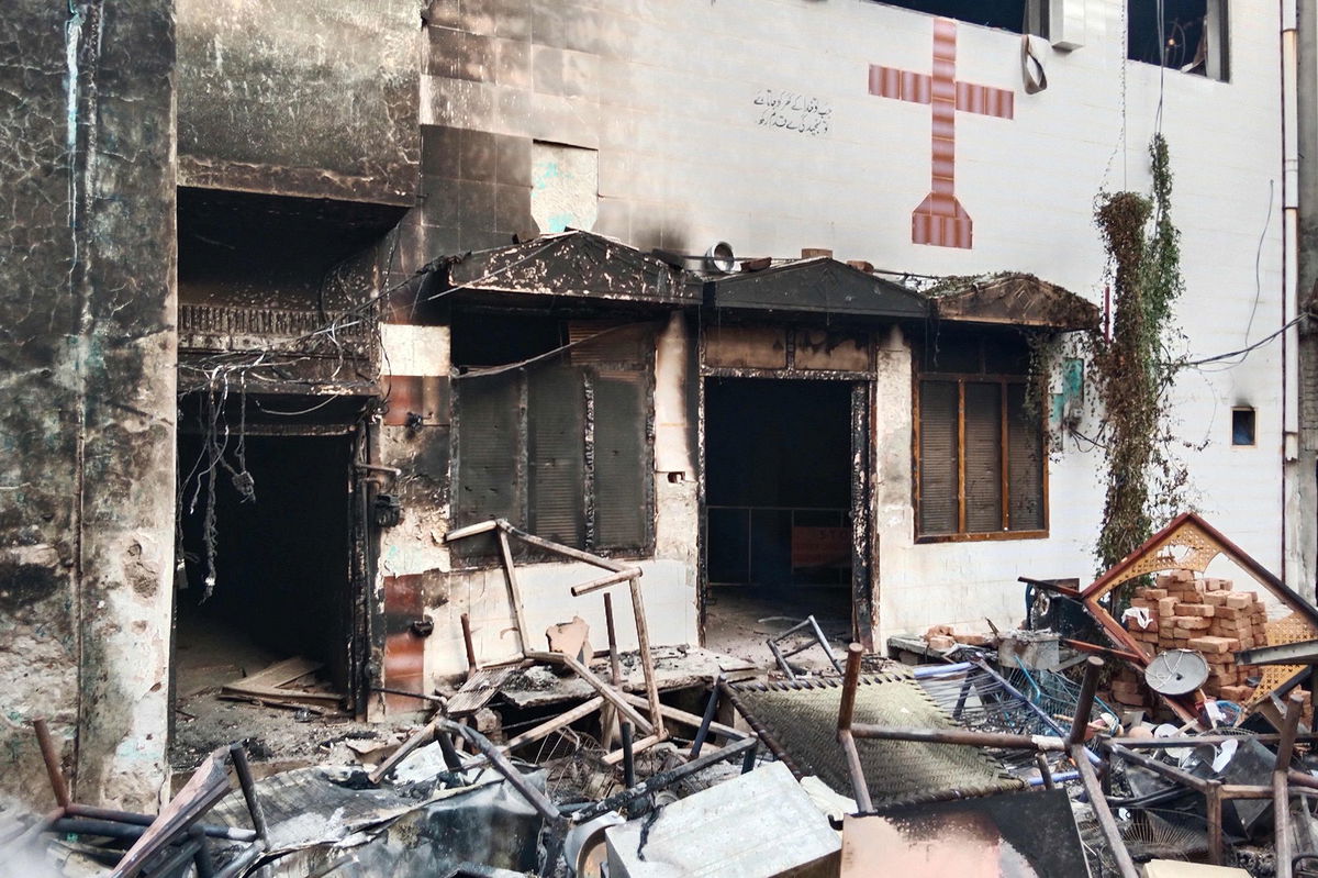 <i>District Police Office/AP</i><br/>Police inspect a house that was set on fire in a Christian neighborhood in Jaranwala on Wednesday.