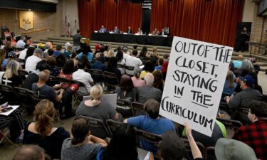 A gay and transgender students' rights supporter holds a sign during a board meeting of the Chino Valley Unified School District at Don Lugo High School in Chino