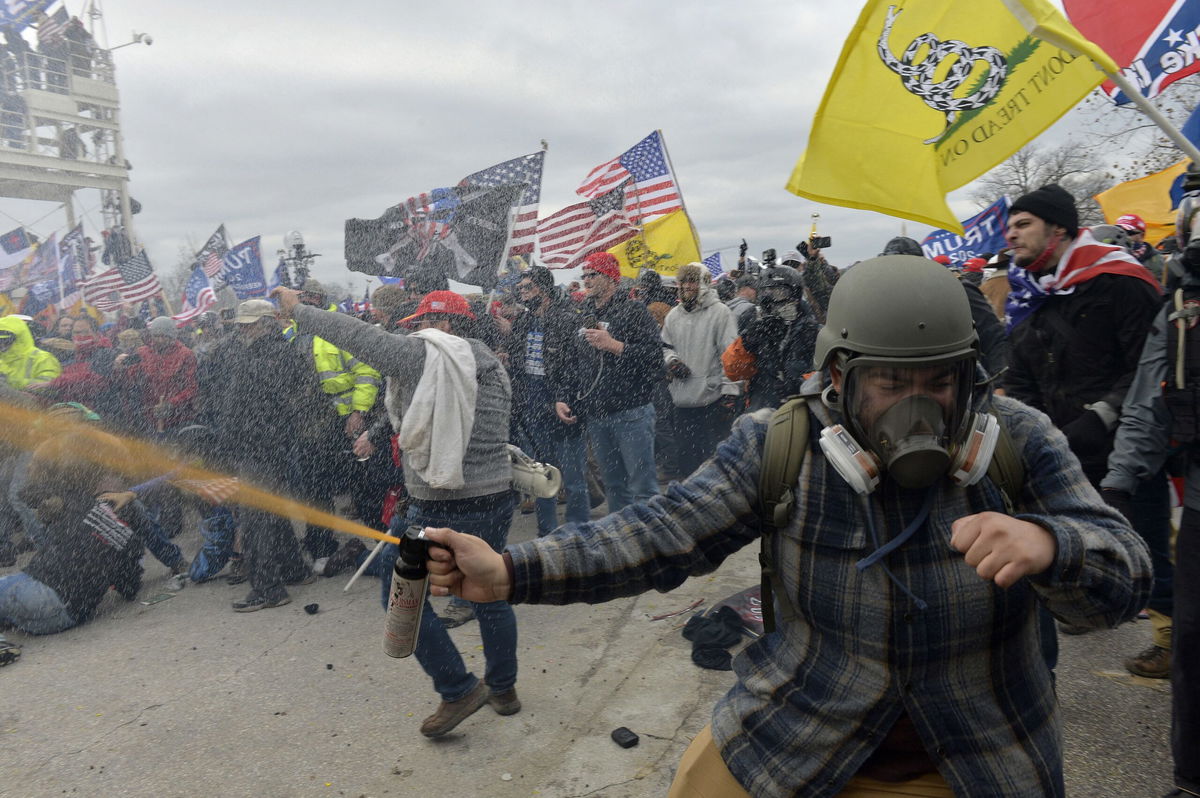 <i>Roberto Schmidt/AFP via Getty Images</i><br/>Riot police push back a crowd of supporters o President Donald Trump after they stormed the Capitol building on January 6