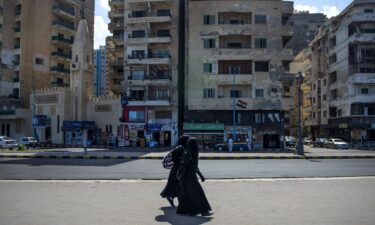 Two women walk by the corniche in Alexandria