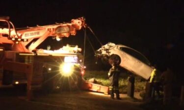 A tow truck retrieves a car after it drove off a cliff near Pescadero State Beach