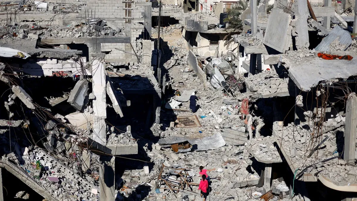 Palestinian children walk among the houses destroyed at Khan Younis refugee camp in the southern Gaza Strip on November 29, 2023