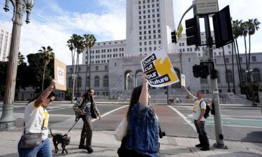 Staff and supporters of the Los Angeles Times carry signs across the street from Los Angeles City Hall during a rally on Friday