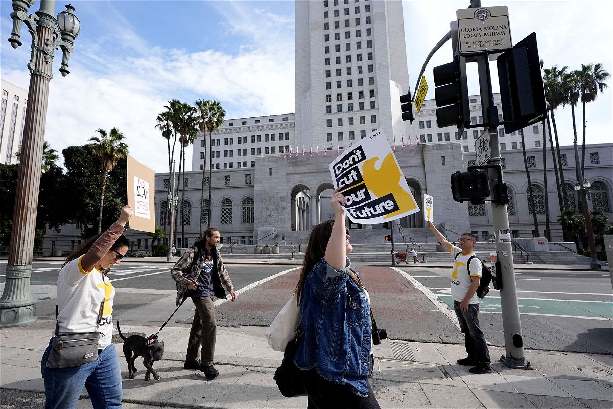 <i>Richard Vogel/AP</i><br/>Staff and supporters of the Los Angeles Times carry signs across the street from Los Angeles City Hall during a rally on Friday