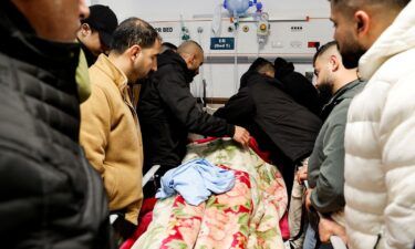 Mourners grieve next to the body of a Palestinian man killed in the raid.