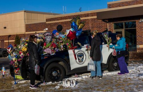 People gather at one of three memorials outside the Burnsville Police Department and City Hall building in Burnsville