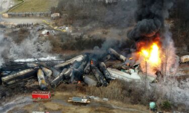 Portions of a Norfolk Southern freight train that derailed the night before burn in East Palestine