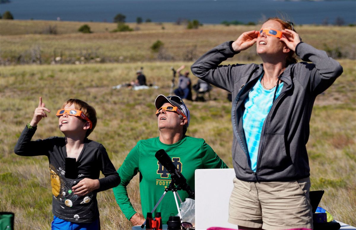<i>Rick Wilking/Reuters/File via CNN Newsource</i><br/>People watch the 2017 total solar eclipse in Guernsey