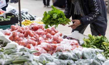 An employee arranges the display on a fruit and vegetable stall in Watney market in London in March.