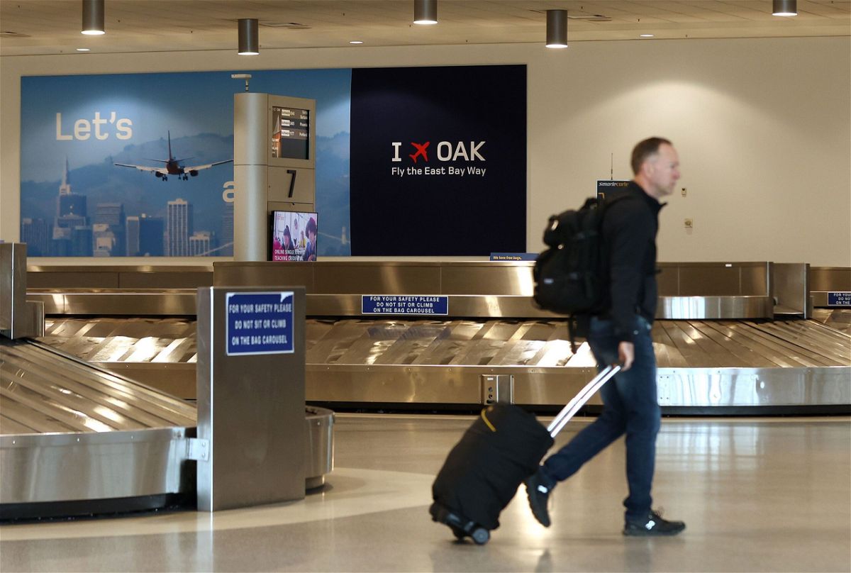 <i>Justin Sullivan/Getty Images via CNN Newsource</i><br/>A traveler walks through baggage claim in Terminal 2 at Oakland International Airport on April 12.