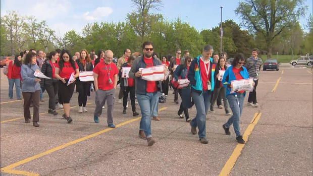 <i>KCNC via CNN Newsource</i><br/>Teachers at Denver's South High School walked in before class began for the day. Teachers and staff wore red shirts and carried signs.