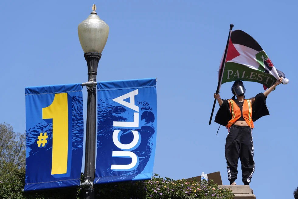 Demonstrators wave flags on the UCLA campus, after nighttime clashes between Pro-Israel and Pro-Palestinian groups, May 1, 2024, in Los Angeles. If the University of California, one of the largest public university systems in the country, were to agree to divestment calls from students protesting the Israel-Hamas war, the system would lose $32 billion of its overall $175 billion in assets, officials said on Tuesday, May 15, 2024. 