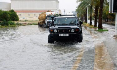 A driver navigates a flooded road following a rainstorm in Dubai on May 2