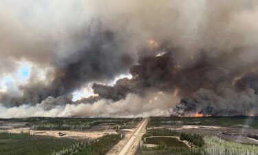 The Parker Lake Fire glows in an aerial photograph taken by a British Columbia Emergency Health Services crew member through the window of an airplane evacuating patients from nearby Fort Nelson