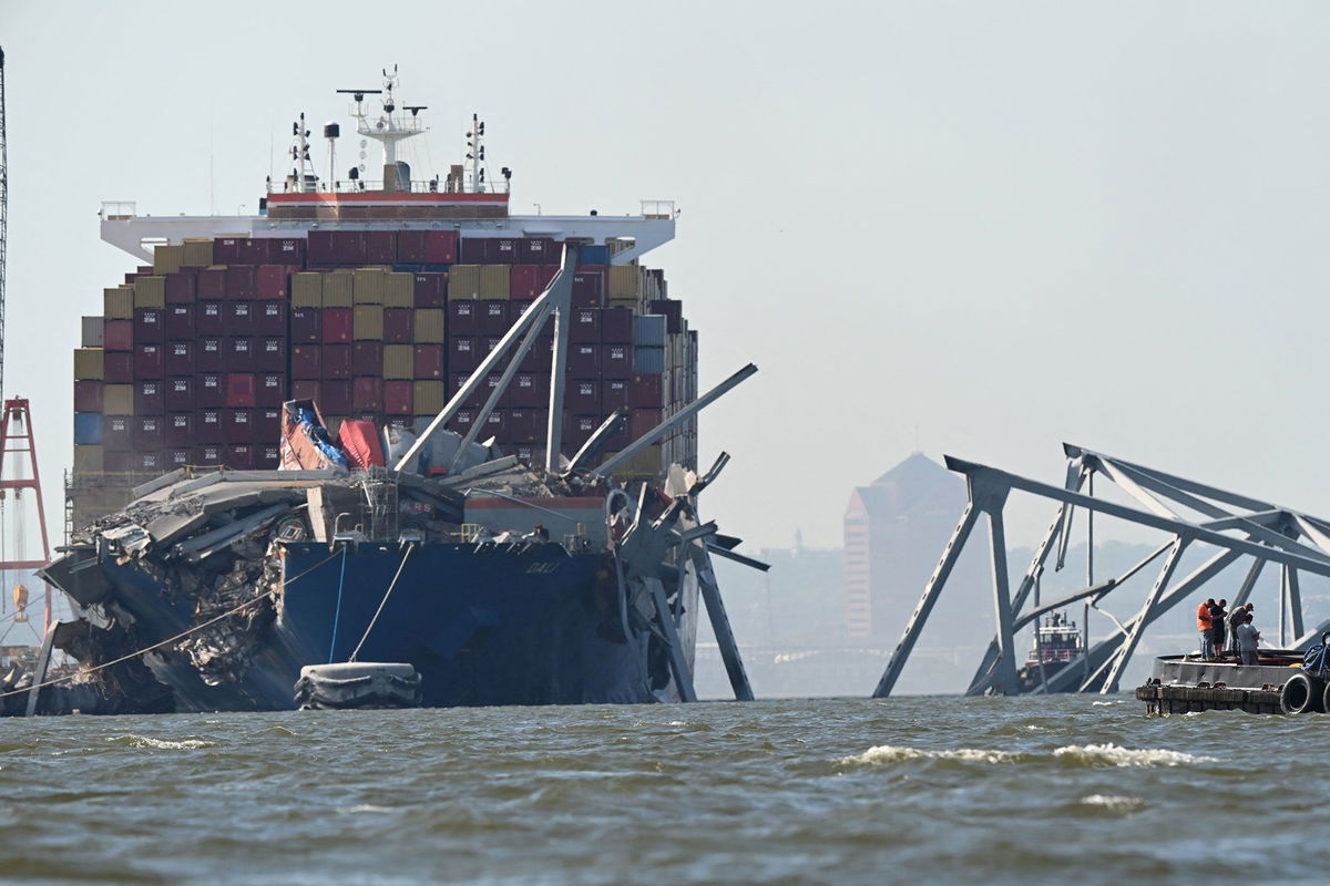 A section of the Francis Scott Key Bridge rests in the water next to the Dali container ship in Baltimore on May 13, after crews conducted a controlled demolition.