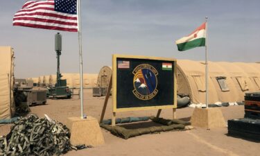 The flags of the United States and of Niger are raised side by side at the base camp for air forces and other personnel supporting the construction of Niger Air Base 201 in Agadez in April 2018.