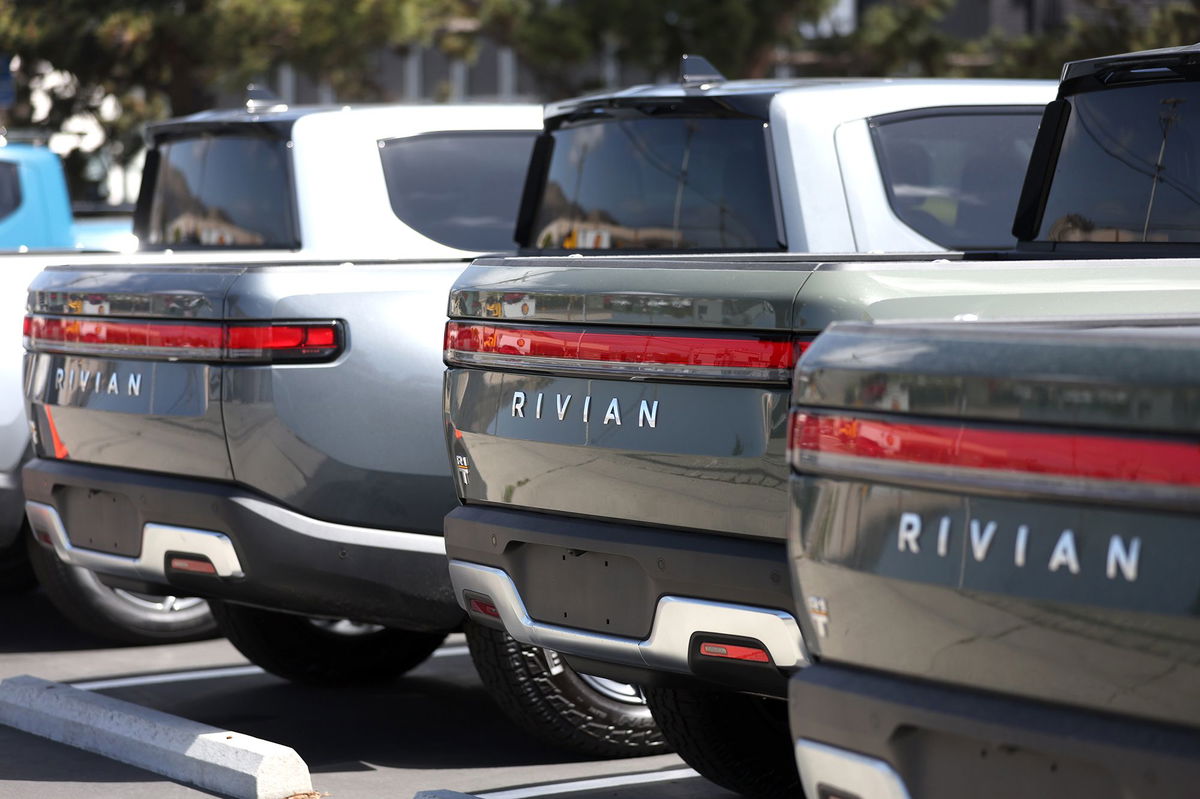 <i>Justin Sullivan/Getty Images via CNN Newsource</i><br/>Rivian electric pickup trucks sit in a parking lot at a Rivian service center in May 2022 in South San Francisco