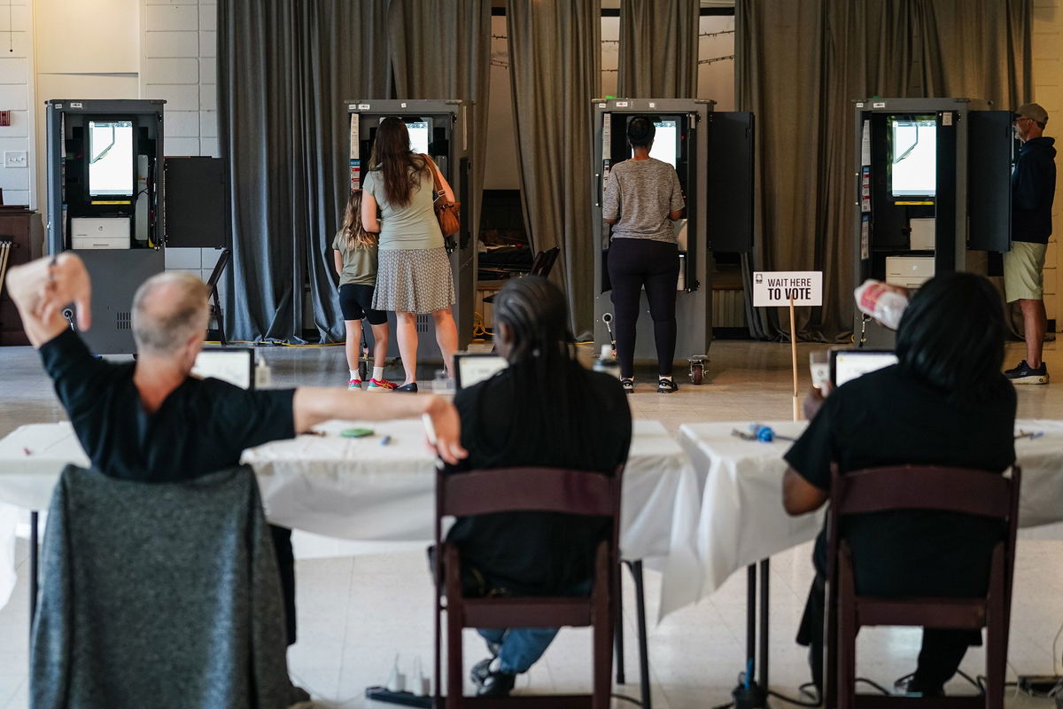 <i>Elijah Nouvelage/Getty Images/File via CNN Newsource</i><br/>A Fulton County Elections worker stretches his arms as voters cast ballots in Georgia's primary election at a polling location in Atlanta