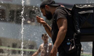 A person cools off in a water fountain by the Hudson River as a heat wave hits the northeast US on June 20