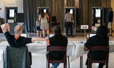 A Fulton County Elections worker stretches his arms as voters cast ballots in Georgia's primary election at a polling location in Atlanta