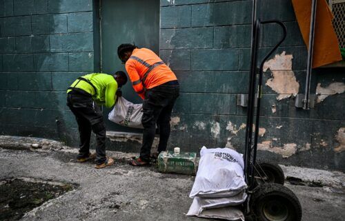 Workers put bags of sand at the back door of a shop on June 30 in preparation for the arrival of Hurricane Beryl in Bridgetown