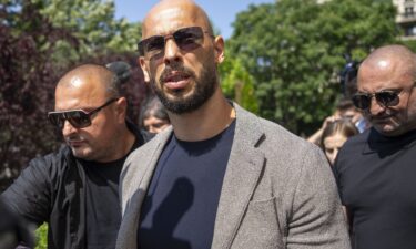 Andrew Tate walks between bodyguards in Bucharest