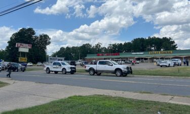 Police vehicles remain on the scene of a shooting at the Mad Butcher grocery store on June 21