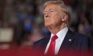 Former President Donald Trump waits on stage to speak at a campaign rally on Wednesday