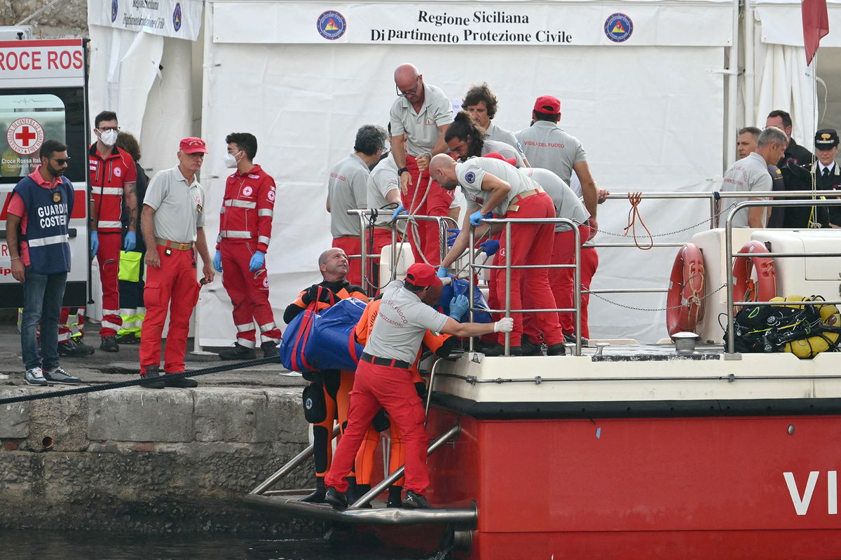 <i>Alberto Pizzoli/AFP/Getty Images via CNN Newsource</i><br/>Rescuers carry a body after divers return in Porticello harbor in Sicily