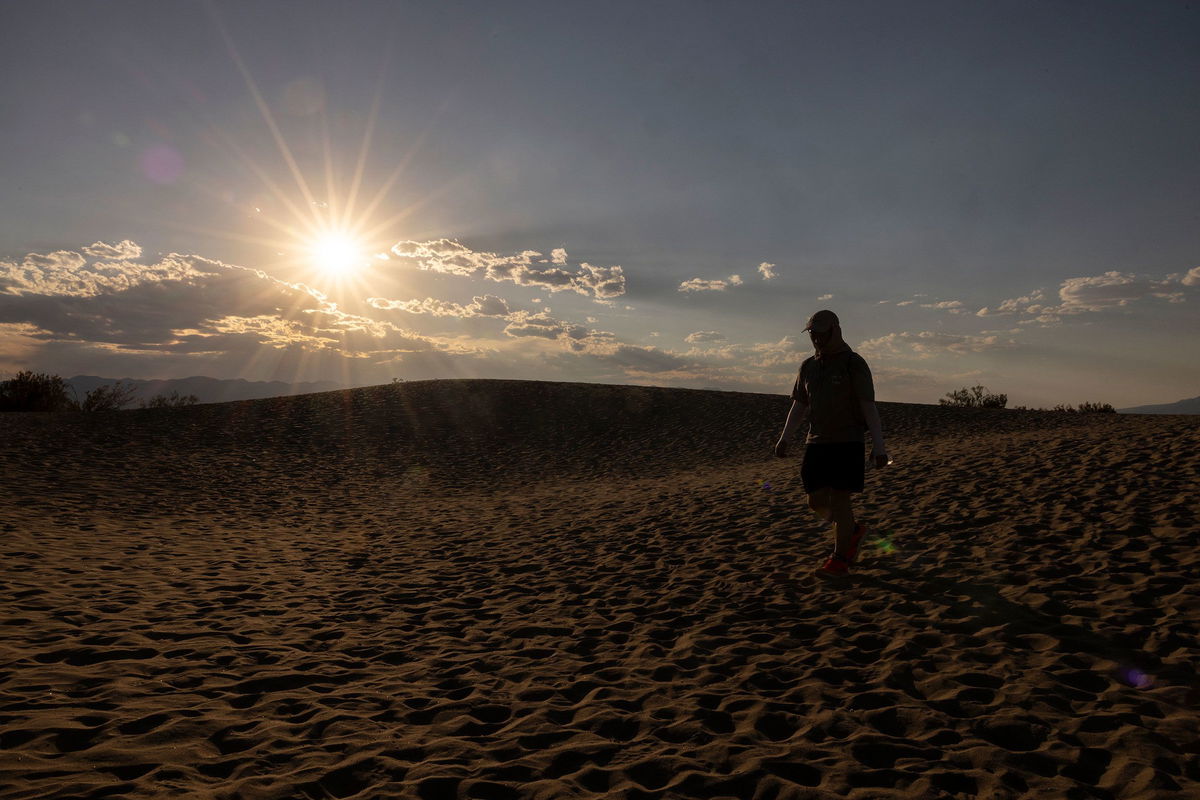 <i>Etienne Laurent/AFP/Getty Images via CNN Newsource</i><br/>A tourist hikes in the Mesquite Flat Sand Dunes in Death Valley National Park