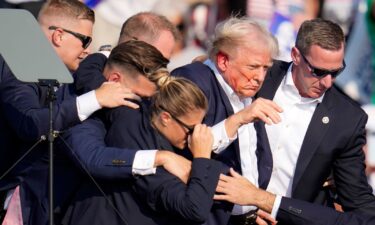 Former President Donald Trump is helped off the stage by US Secret Service agents at a campaign event in Butler