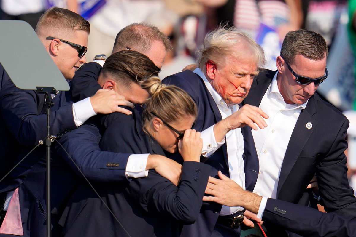 <i>Gene J. Puskar/AP/File via CNN Newsource</i><br/>Former President Donald Trump is helped off the stage by US Secret Service agents at a campaign event in Butler