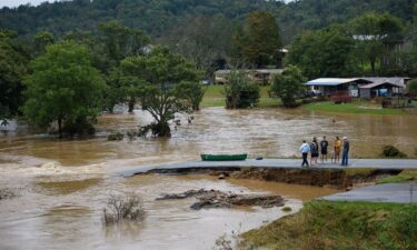 Residents talk after having canoed the flooded South Fork New River for 32 minutes and landing at a washed out road on September 27