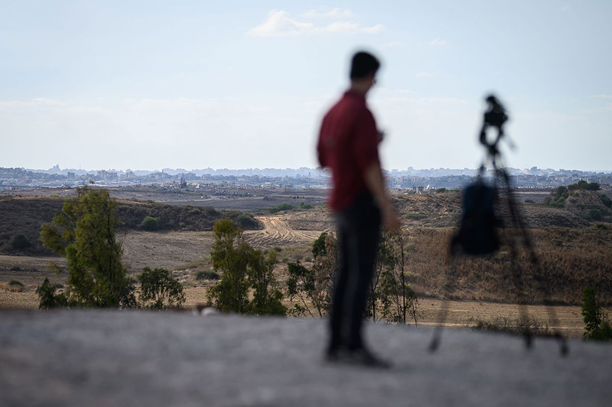 <i>Leon Neal/Getty Images via CNN Newsource</i><br/>A journalist looks towards Gaza from a viewpoint in Southern Israel on October 7 in Sderot