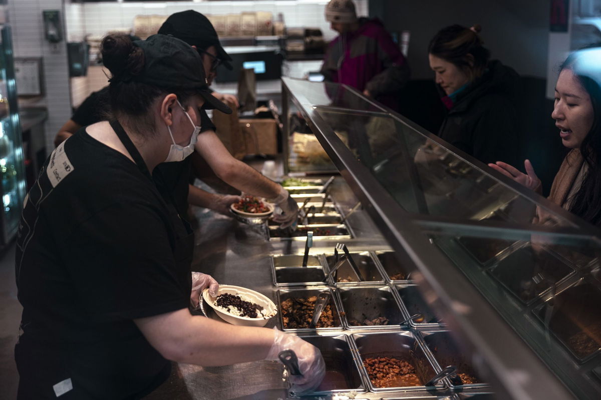 <i>Angus Mordant/Bloomberg/Getty Images/File via CNN Newsource</i><br/>Workers serve food inside a Chipotle restaurant in New York on January 12