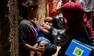 A health worker administers a polio vaccine to a child in a downtown area of Lahore